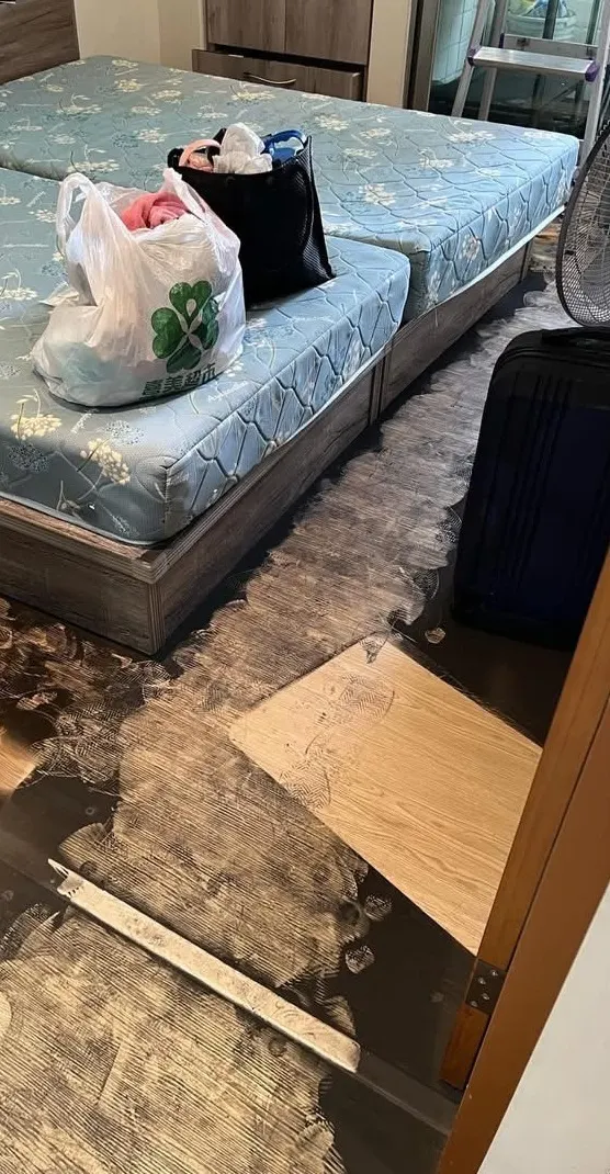 清潔前的臥室,地板有大片黑色污漬