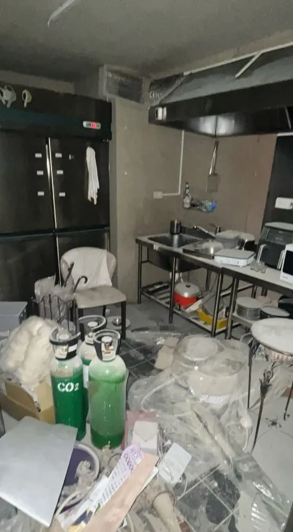 清潔前的廚房,地面堆滿雜物與粉塵